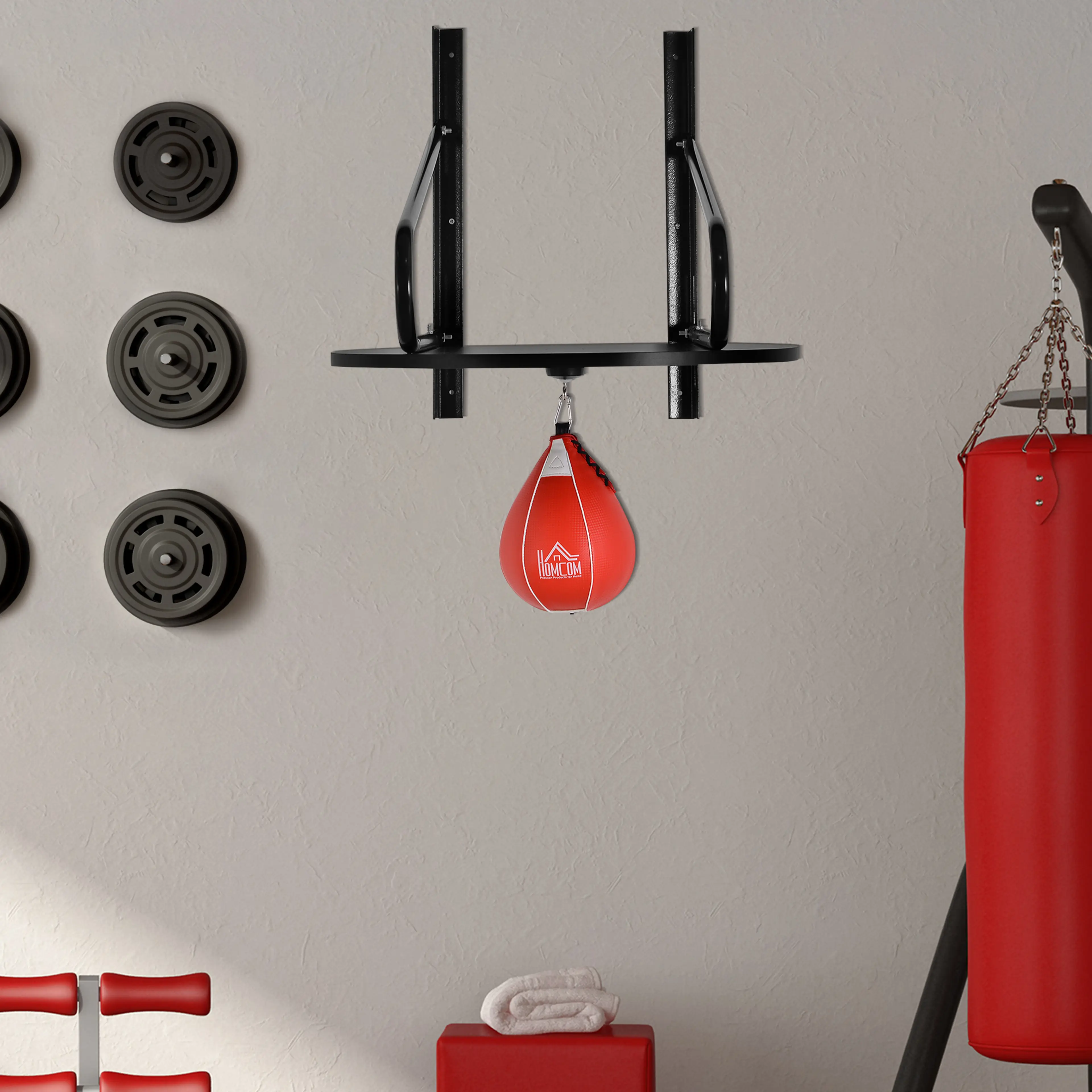 Boxbollen monterad på en gymvägg bredvid en boxningssäck