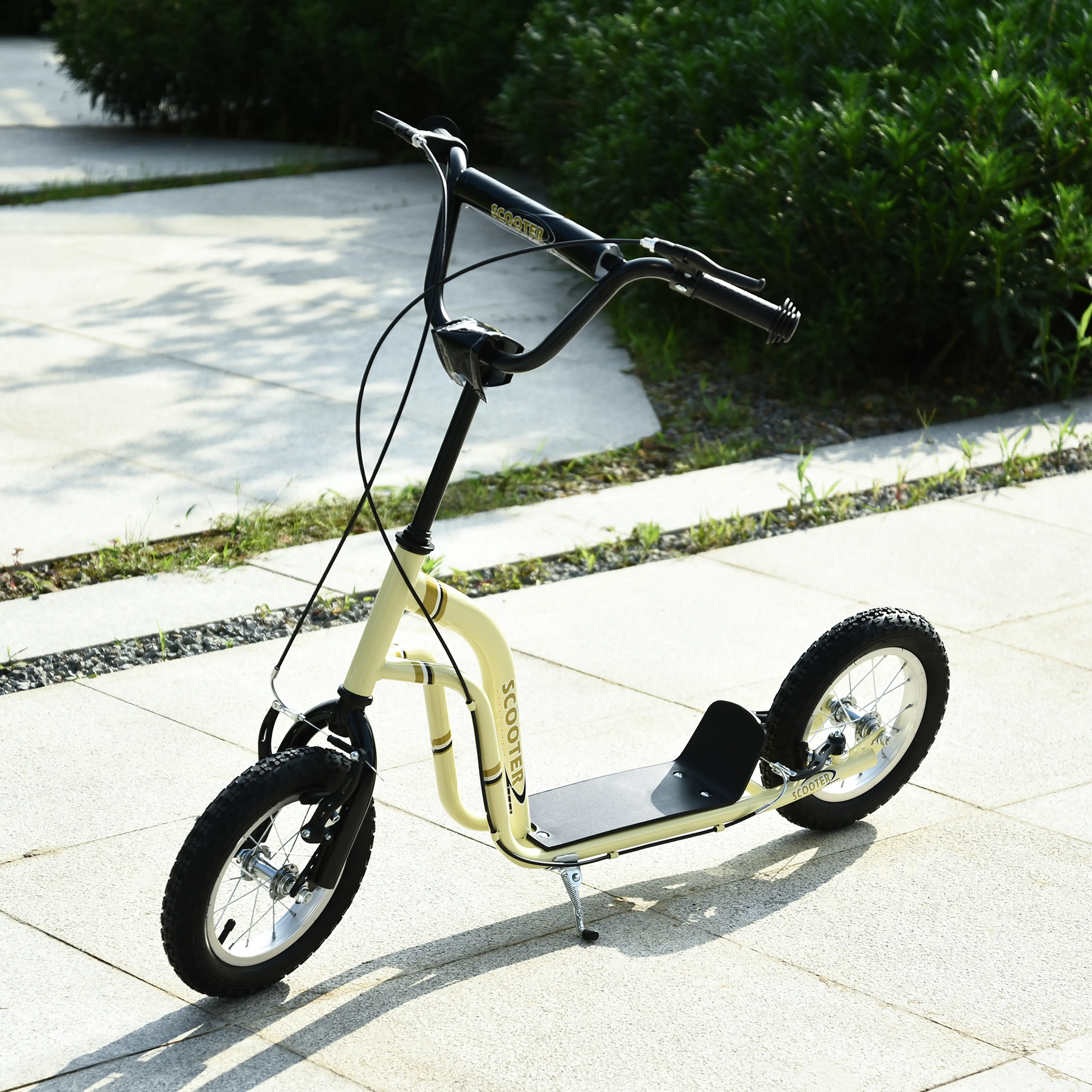 Den gräddbeige sparkcykeln uppställd på stödbenet på en stenlagd gång