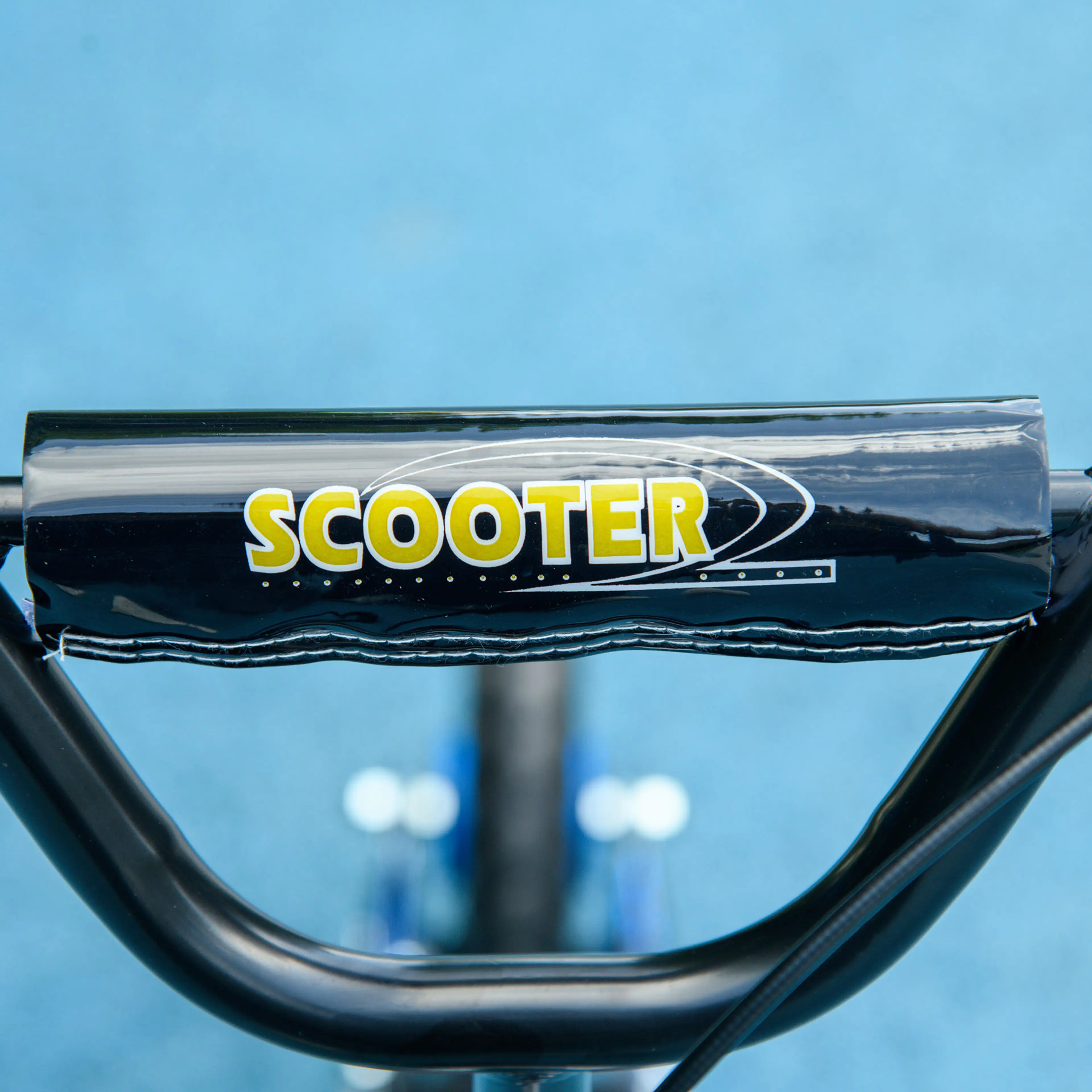 Närbild på styrets stoppning på mörkblå sparkcykel