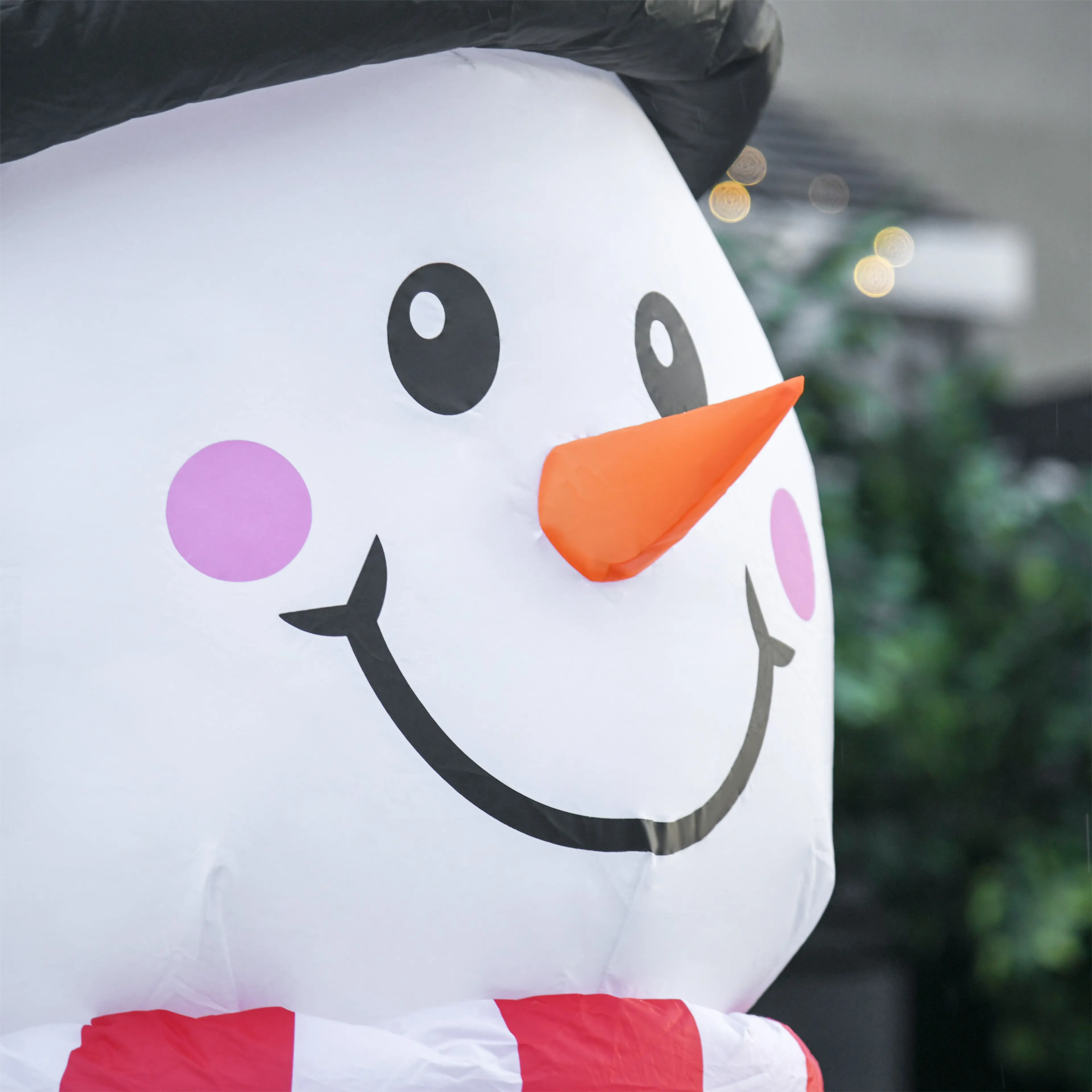 Närbild på snögubbens ansikte med morotsnäsa och rosa kinder