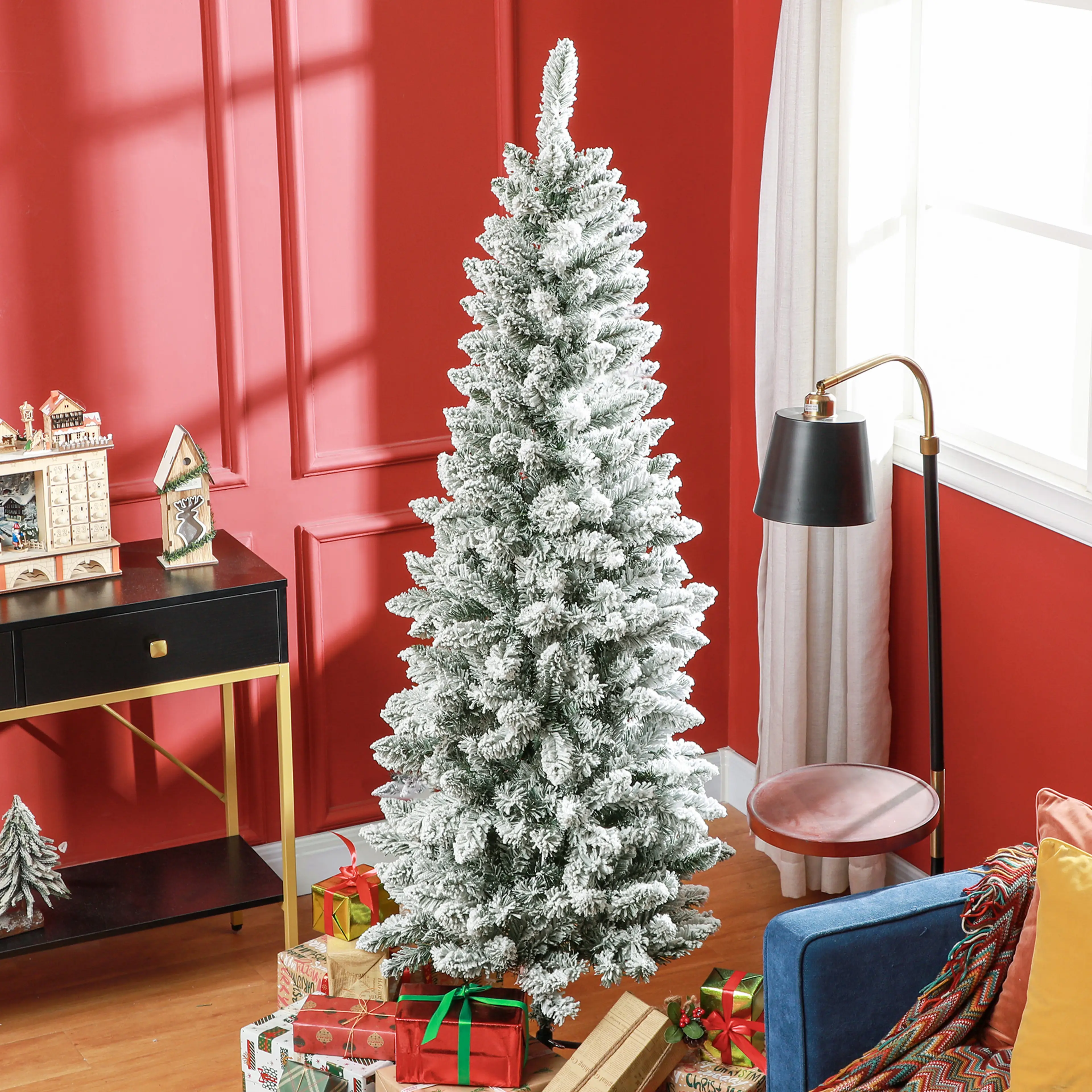 Julgranen i ett rum med röda väggar och julklappar under