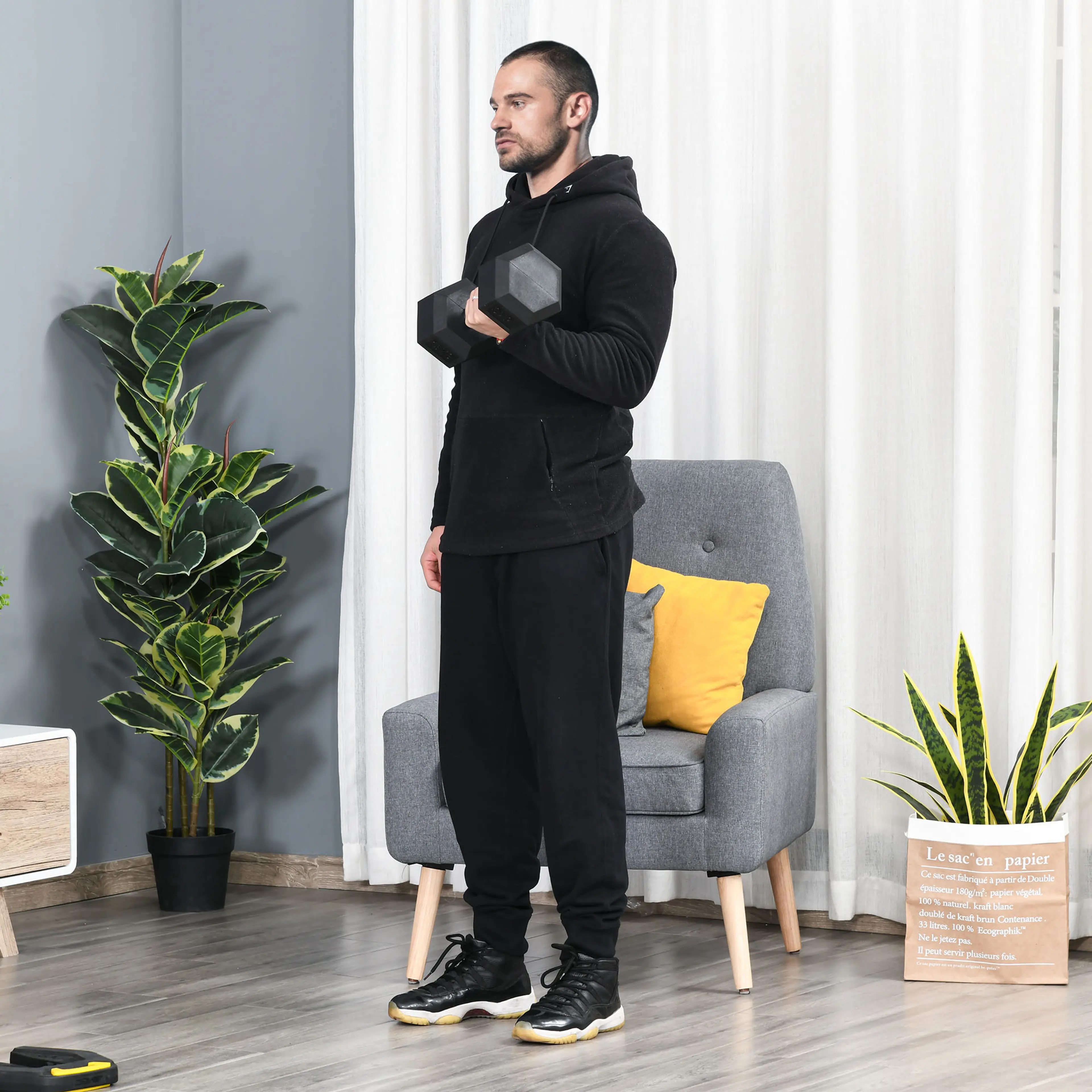 Man tränar bicepscurl med hexhanteln på 15 kg i ett vardagsrum