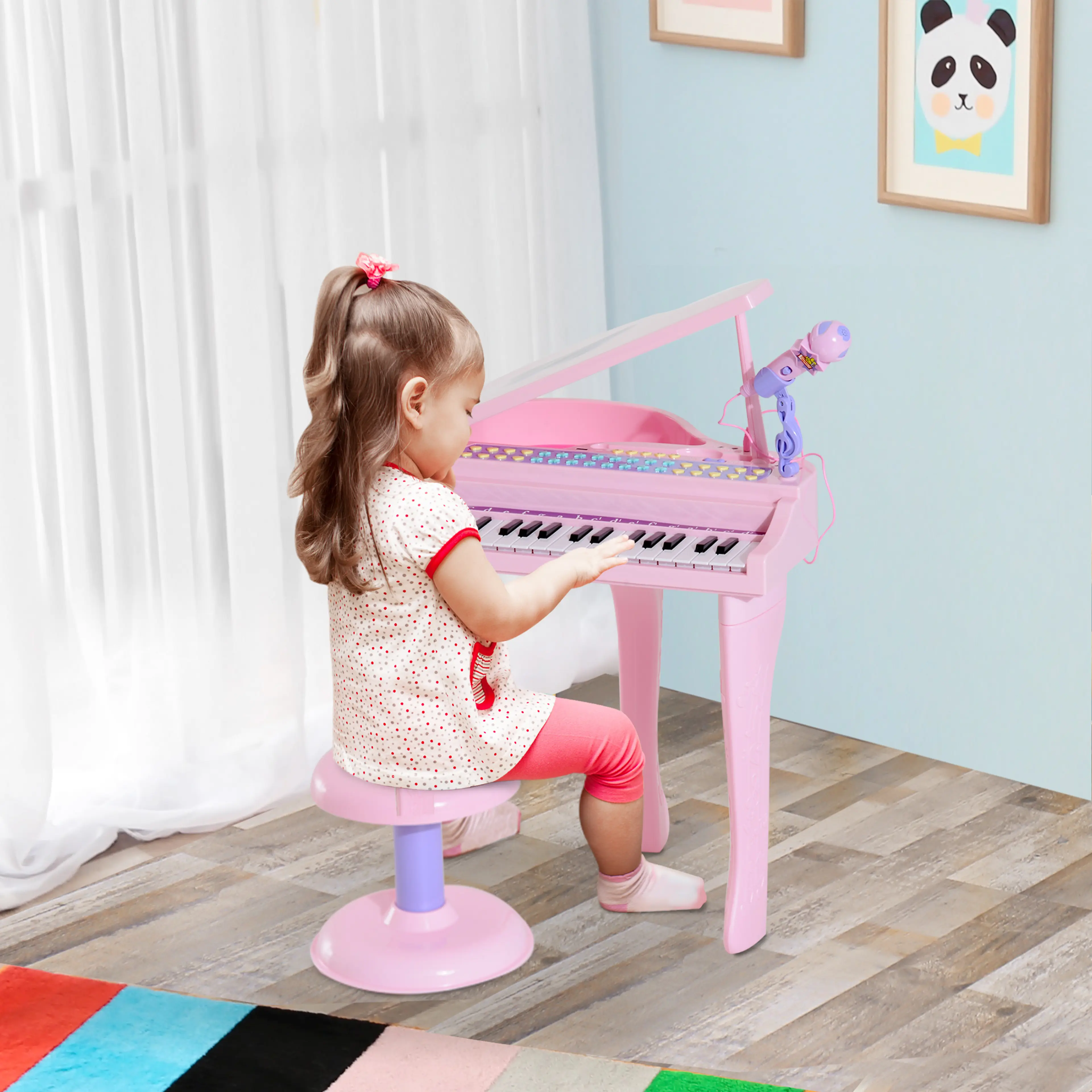 Ett barn spelar på det rosa keyboardet sittande på pallen