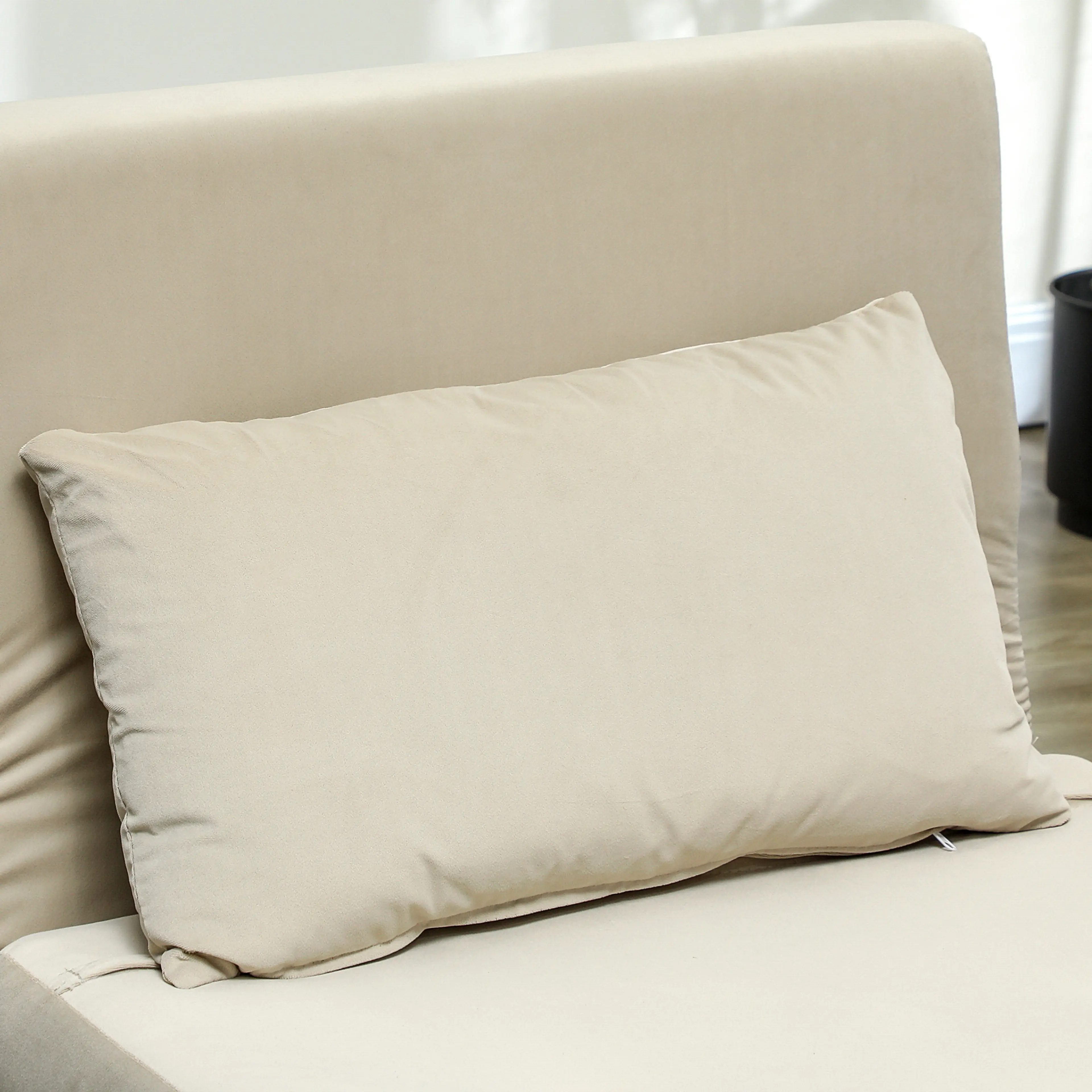 Den utfällda bädden i beige med kudden på plats