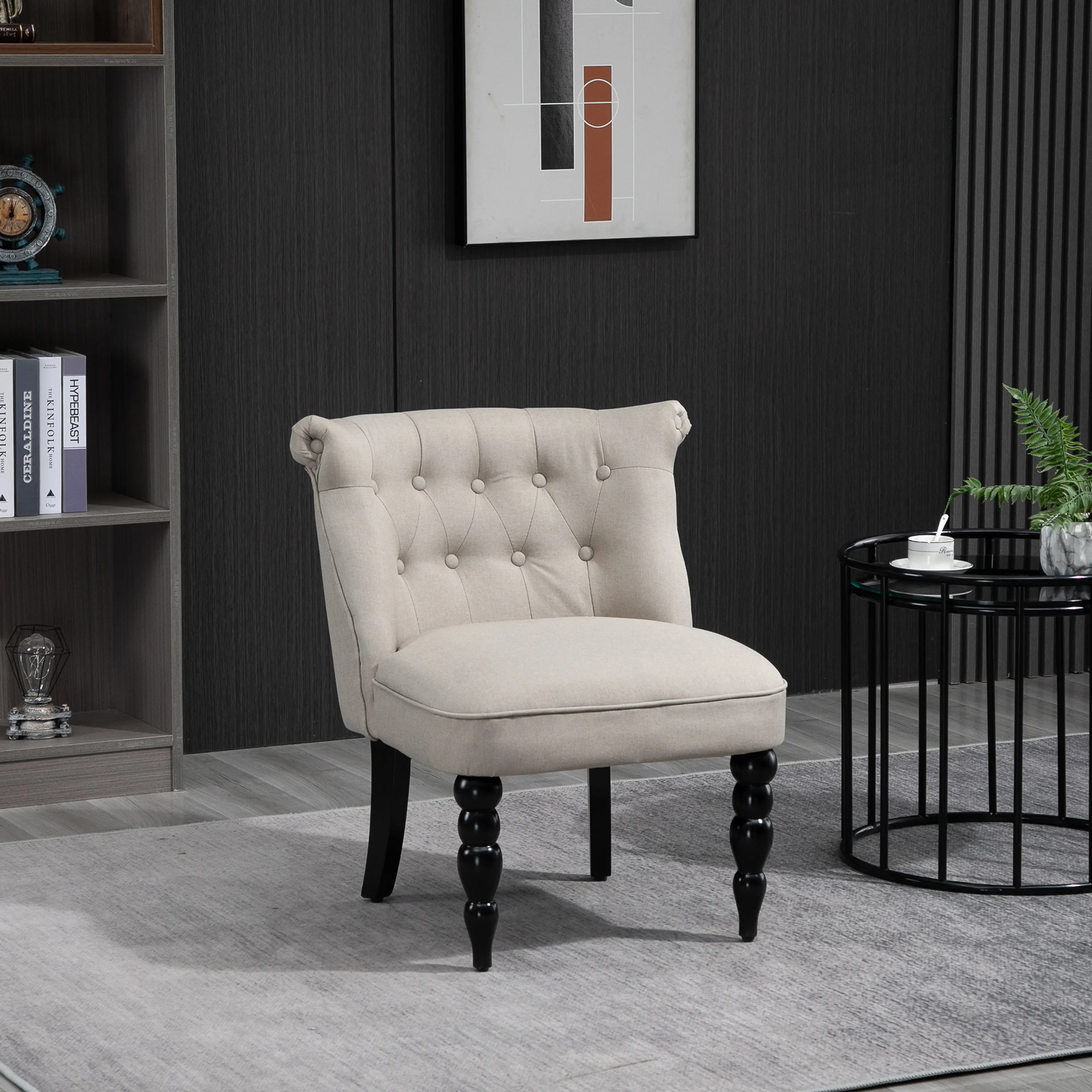 Liten fåtölj i beige linne, i ett rum mot en mörk vägg
