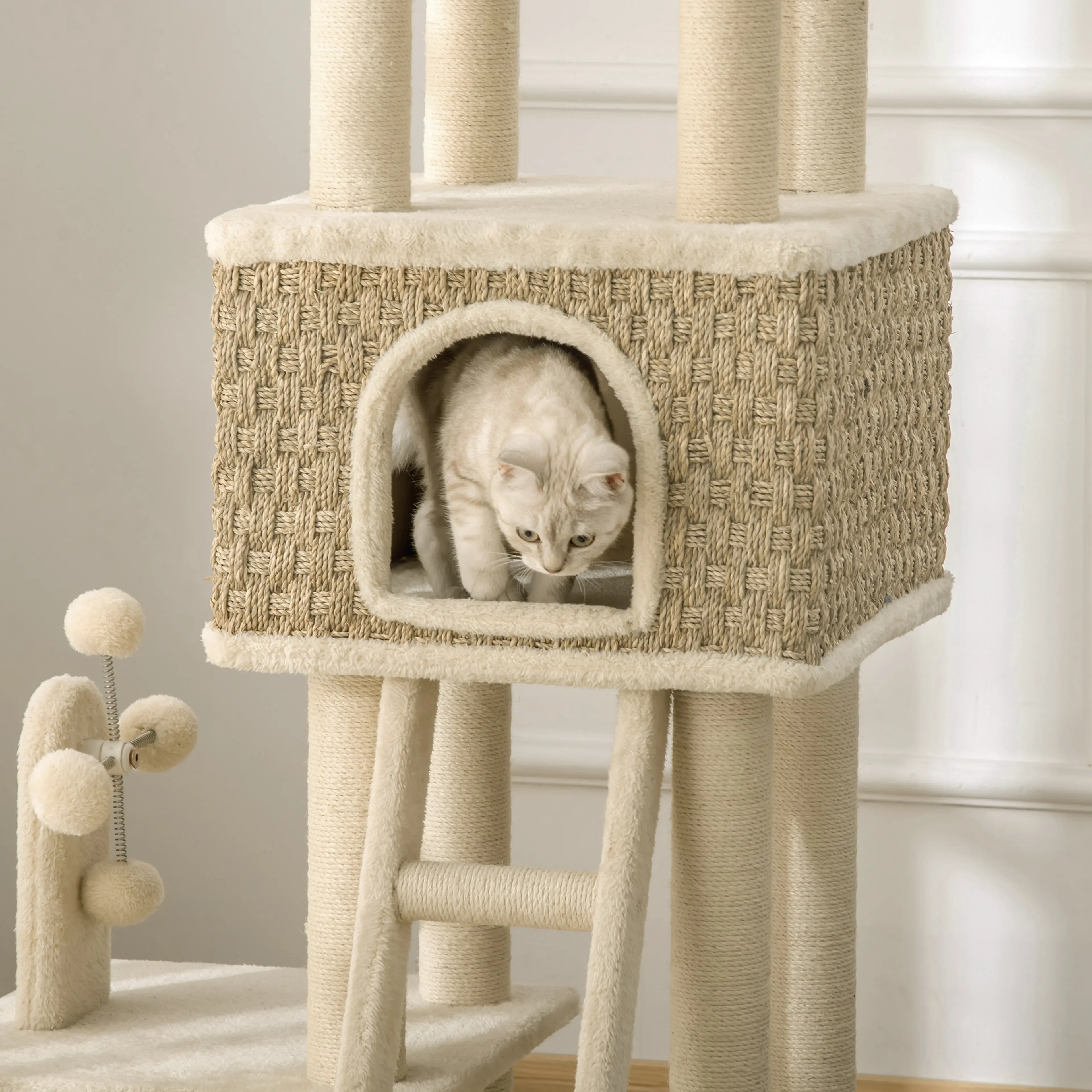 Närbild på huset i flätat sjögräs med en katt i den välvda öppningen