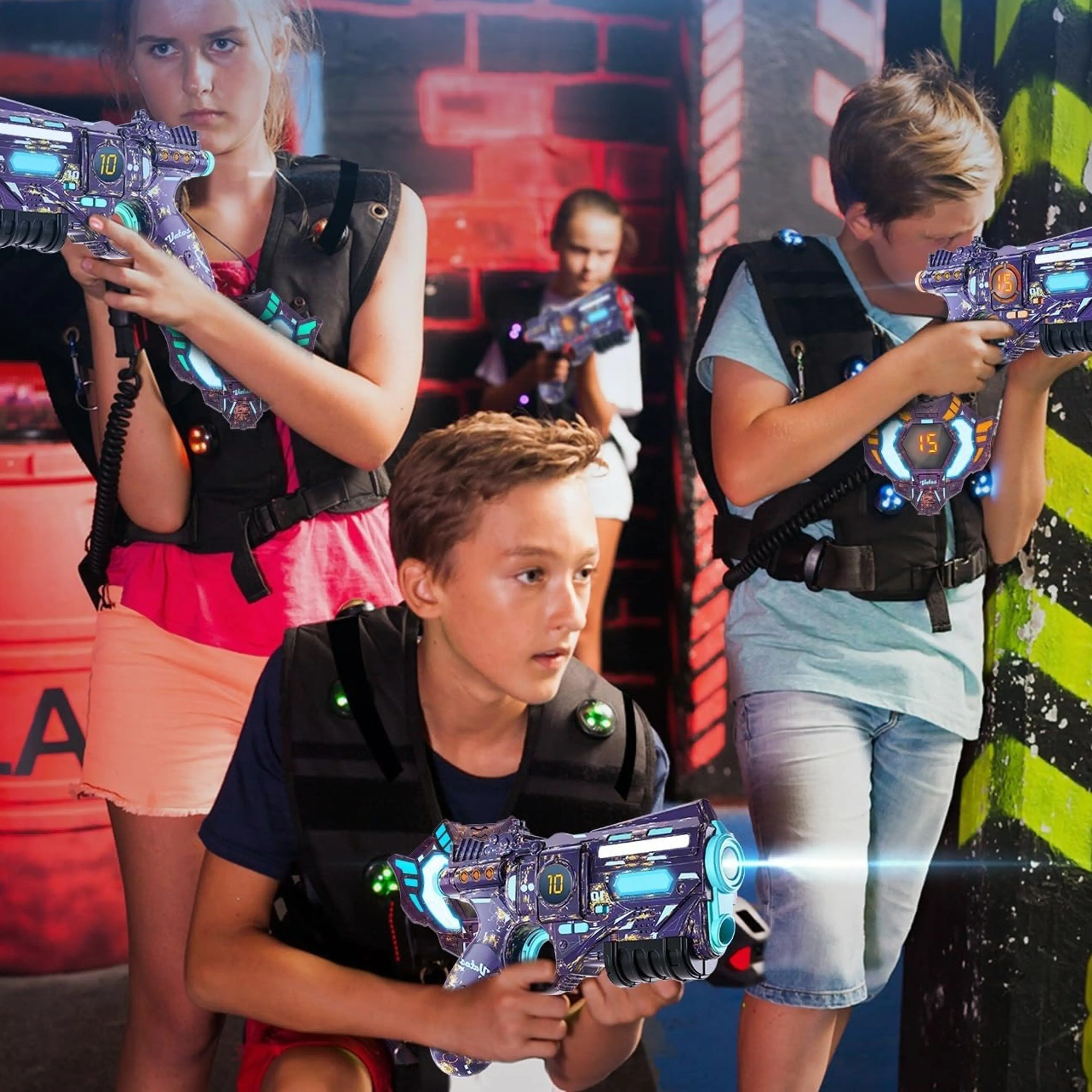 Fyra ungdomar spelar lasertag i en inomhusarena