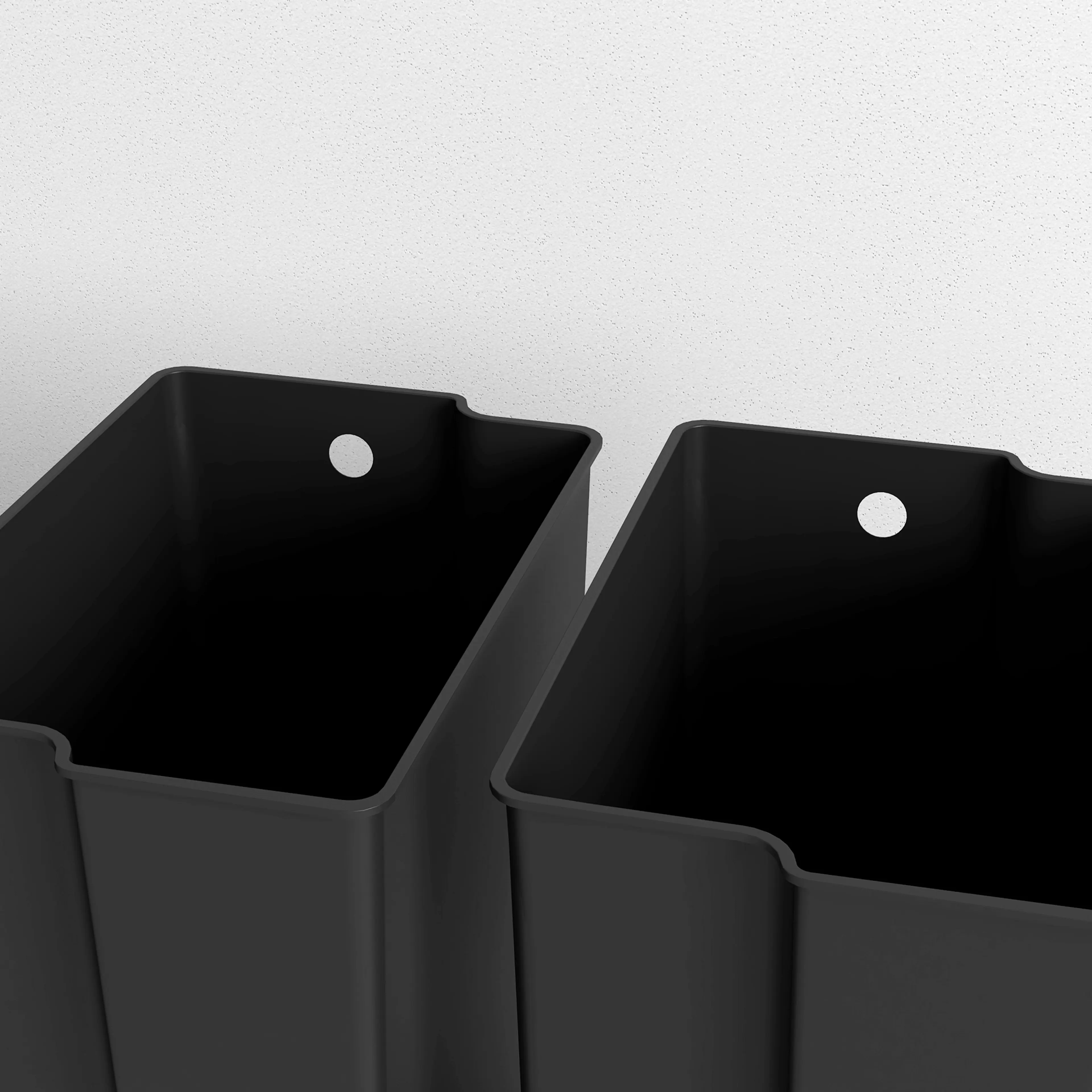 Närbild på de två uttagbara innerhinkarna i svart plast