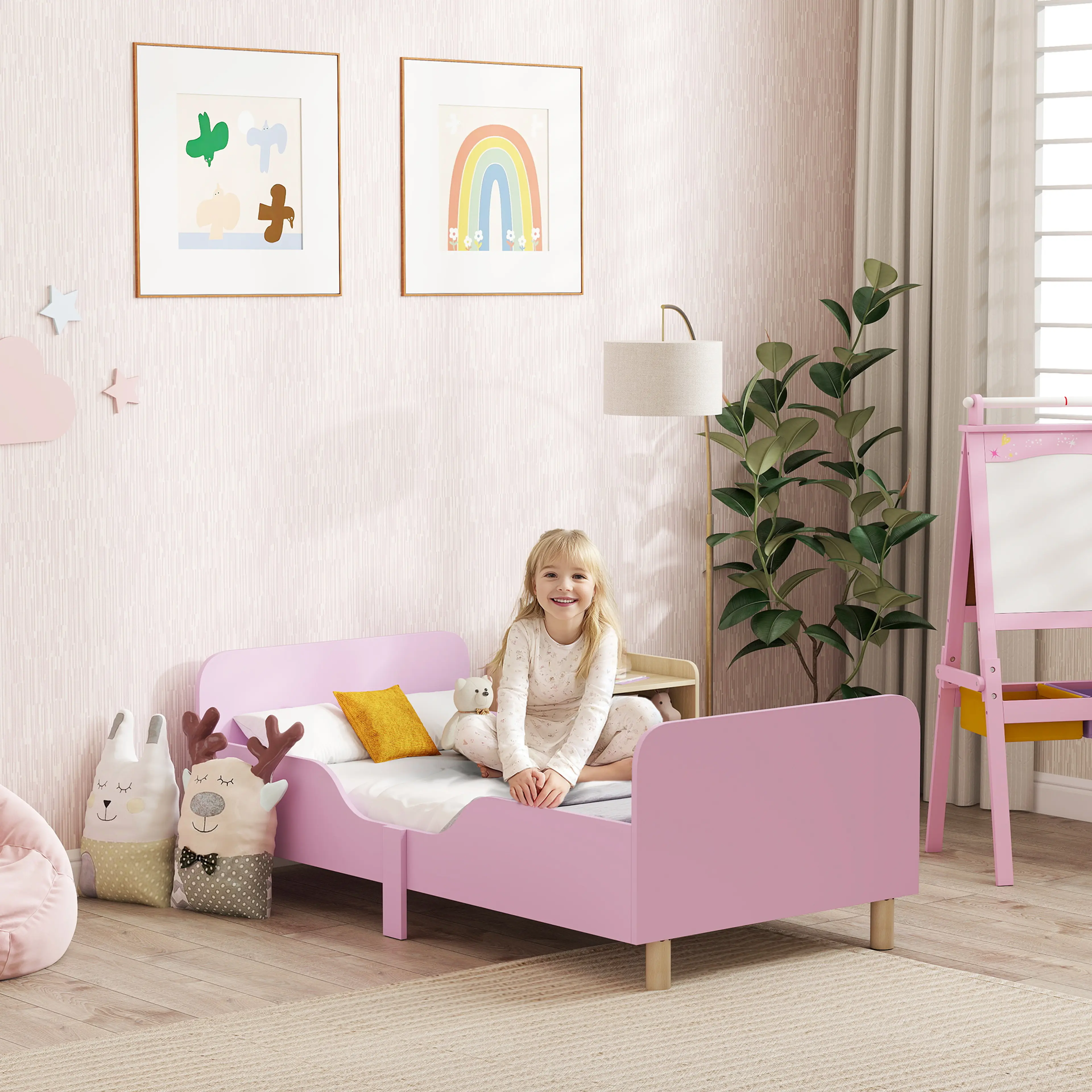 Barn som sitter vid juniorsängen i ett ljust barnrum