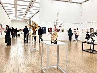 人々がアート展示で絵画や彫刻を鑑賞している様子