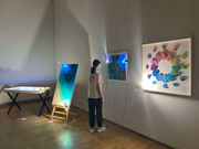 女性が展示されたアート作品を鑑賞。カラフルな光が彩る空間芸術TORAM。