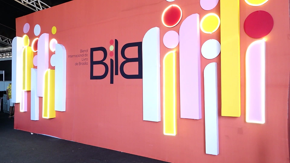 Painel rosa da Bienal Internacional do Livro de Brasília, com formas coloridas e luzes neon, em ambiente de feira.