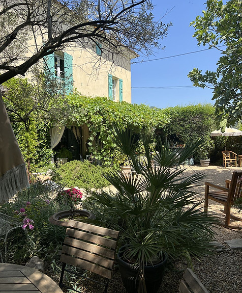 Terrasse des über 200 Jahre alten Bauernhauses im Mas l'Epicure mit schattigem Garten und gemütlicher Sitzecke