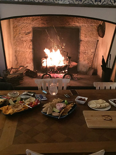 Dinner laid out on the table in front of the fireplace at Château Destinée, the heart of the volunteer evenings