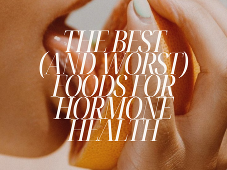 Close-up of a person holding an orange wedge near their mouth. Text reads "The Best (and Worst) Foods for Hormone Health" and "@BYALEORA".