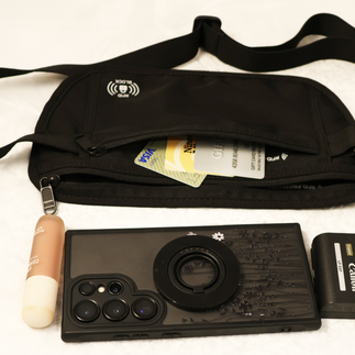 Black waist wallet showing credit cards, lipstick, cell phone, and camera battery that can fit inside