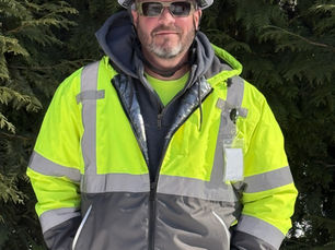 Darin Von-Lehmden, Safety Director at Vernon Nagel, Inc., wearing a white hard hat and high-visibility safety jacket while standing outdoors on a job site.
