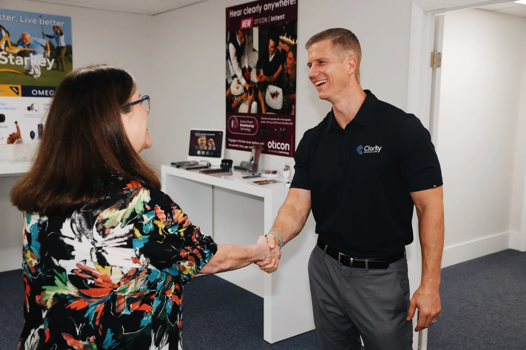Clarity Hearing Care specialist Zack greeting a patient in the clinic.
