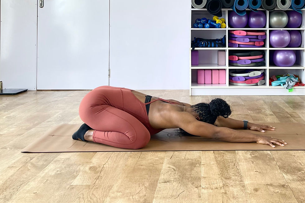 Cynthia, Ophil Founder, demonstrating Child's Pose in a home yoga studio