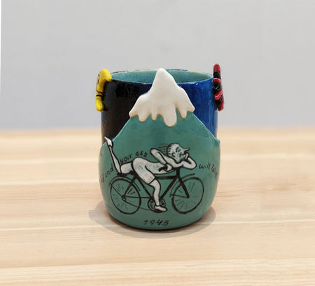 taza de desayuno con una montaña y una persona montando en bicicleta
