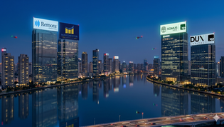 Imagem noturna de um skyline urbano com prédios de escritórios, com painéis luminosos exibindo as logos das empresas Remora Capital, Manchester, Somus e Dux Capital, todas associadas à XP.