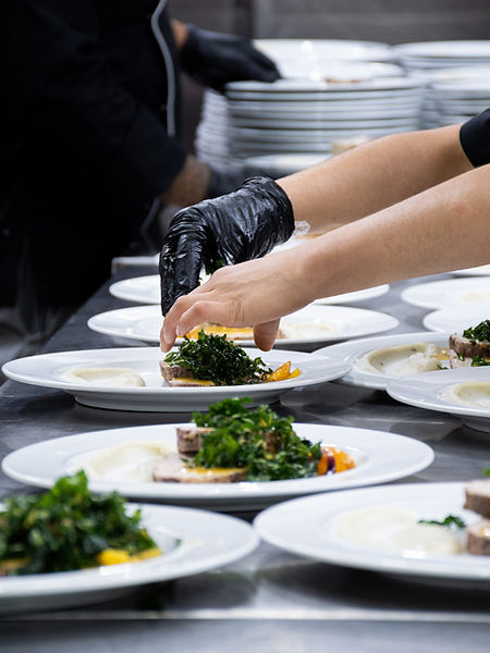 a person in black gloves putting food on