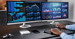 Professional monitoring analytics dashboards across dual screens at a workstation.