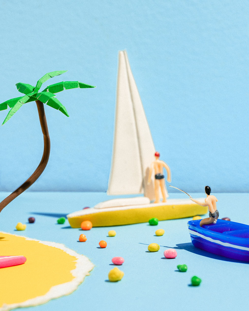 A beach-themed miniature set with characters fishing for Skittles, creating a summer-inspired scene with a tranquil coastal ambiance.