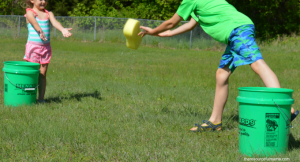 Parents and children tossing sponges soaked in water for outdoor fun
