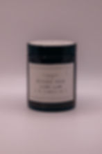 Handgemachte Duftkerze Rêverie Noir in einem minimalistischen Glasdesign mit cremefarbenem Label, neutraler Hintergrund