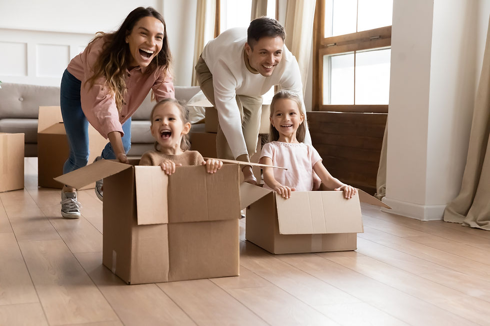 Happy parents playing with children in new apartment living room, two cute little daughter