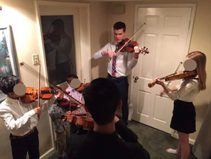 Connor Madsen teaches a group violin class before a concert