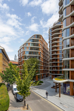 Street-level view of Triptych Bankside in London. A modern residential apartment buildings with curved balconies and landscaped public realm