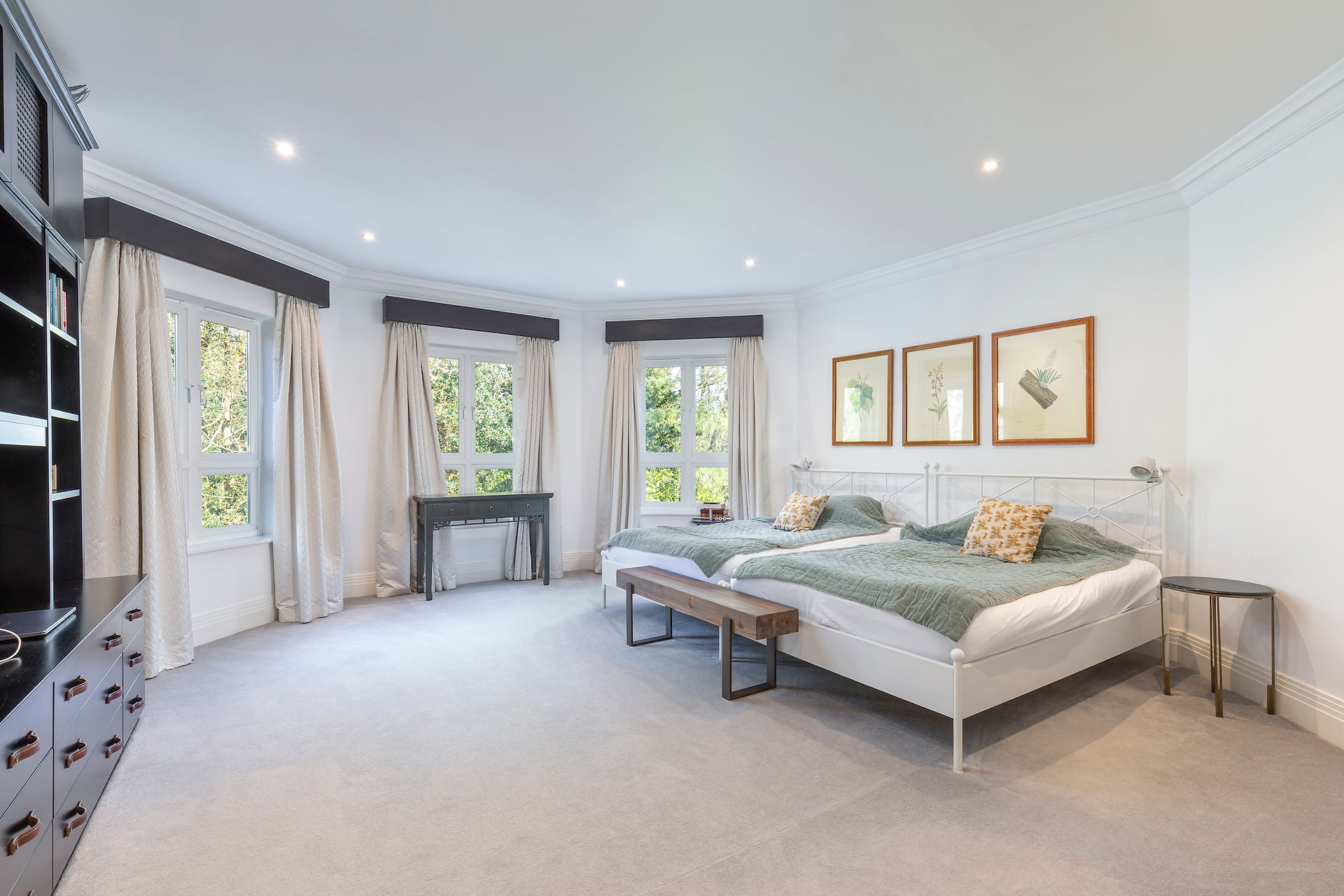 bedroom with two double beds, soft furnishings, fitted storage and multiple windows providing natural light