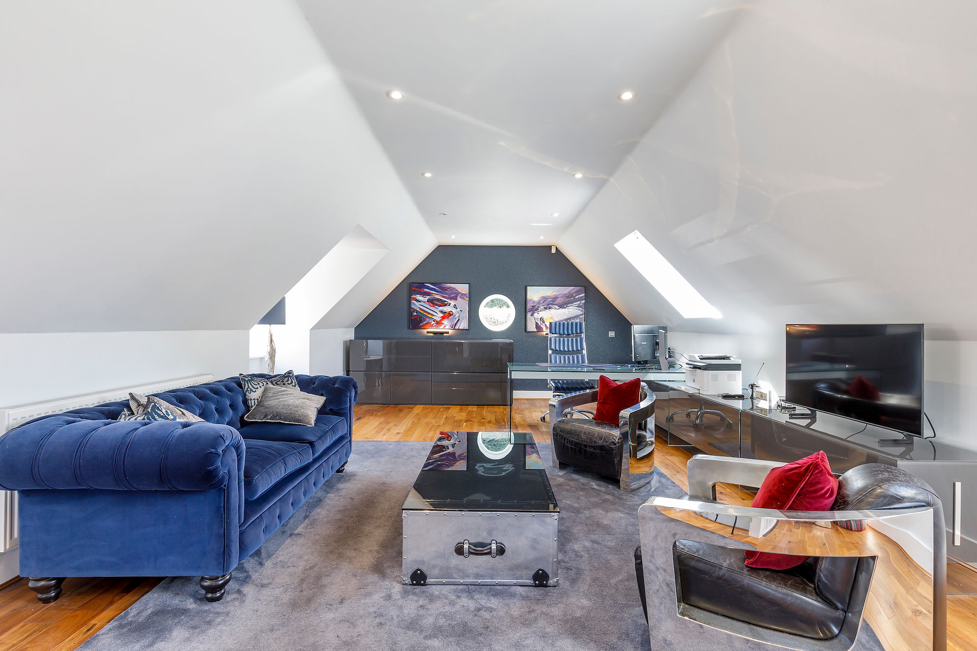 Stylish loft conversion with vaulted ceiling, home office setup and seating area, professionally photographed UK property interior