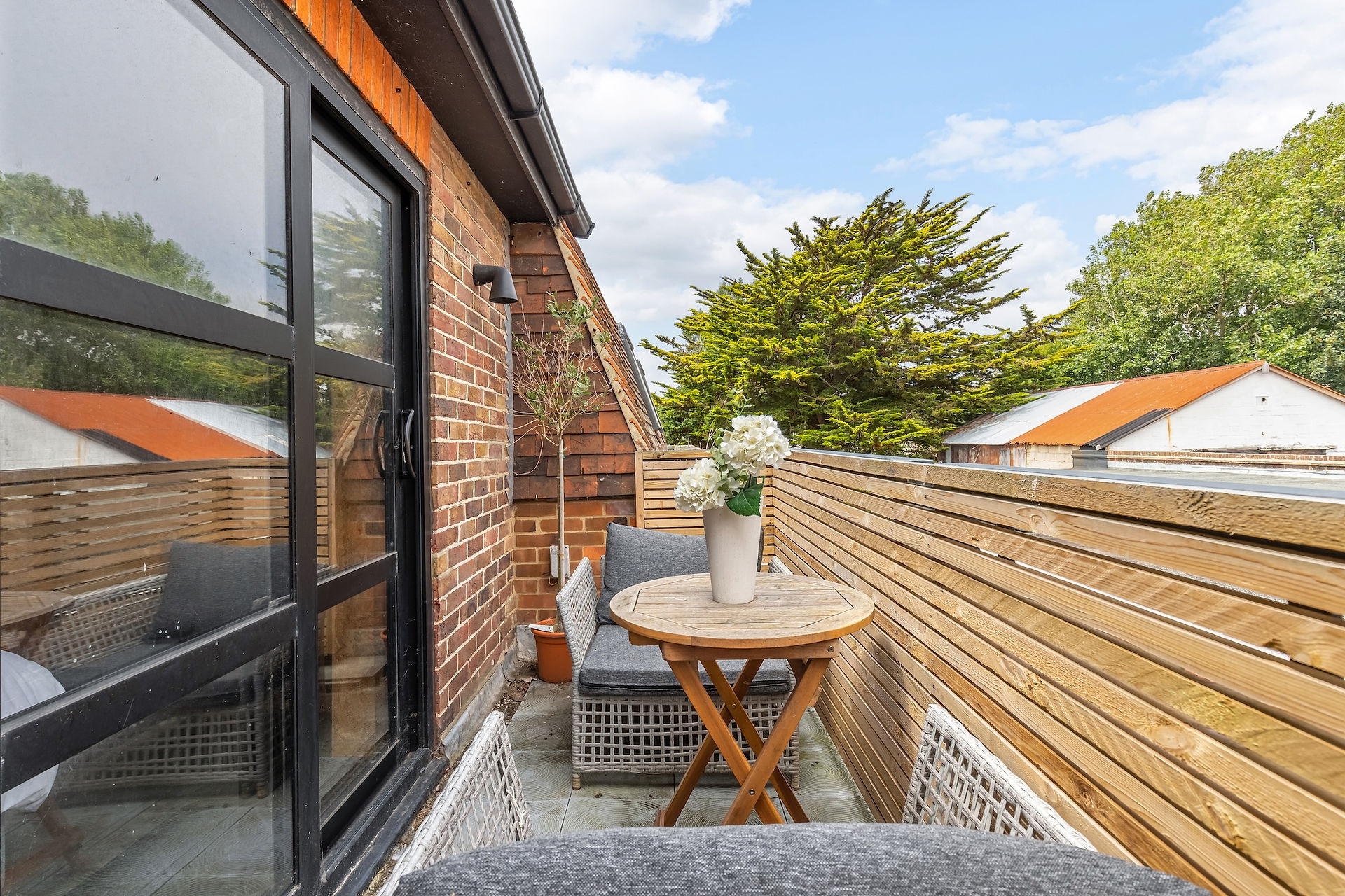 Private balcony with outdoor seating, timber screening and garden outlook