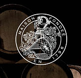 Logo des Weinguts Buitenverwachting vor Holzfässern im Weinkeller in Constantia.