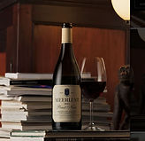 Flasche Rotwein von Meerlust mit Weinglas in einem stilvollen Innenraum.