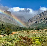 Regenbogen über den Weinbergen von Oldenburg vor den Bergen des Banghoek Valley.