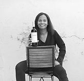 Frau präsentiert eine Flasche Rotwein von Vilafonté in einer schwarz-weißen Porträtaufnahme.