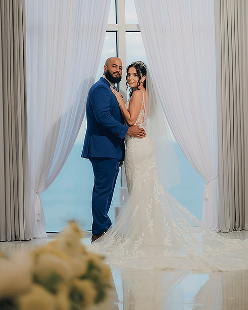 Couple posing in the ceremony room, overlooking the beach at the Crystal Ballroom Ocean Walk.