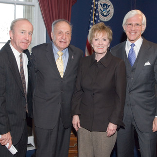 Four people standing together in an office: three men in suits and Kay Granger in a dark jacket.