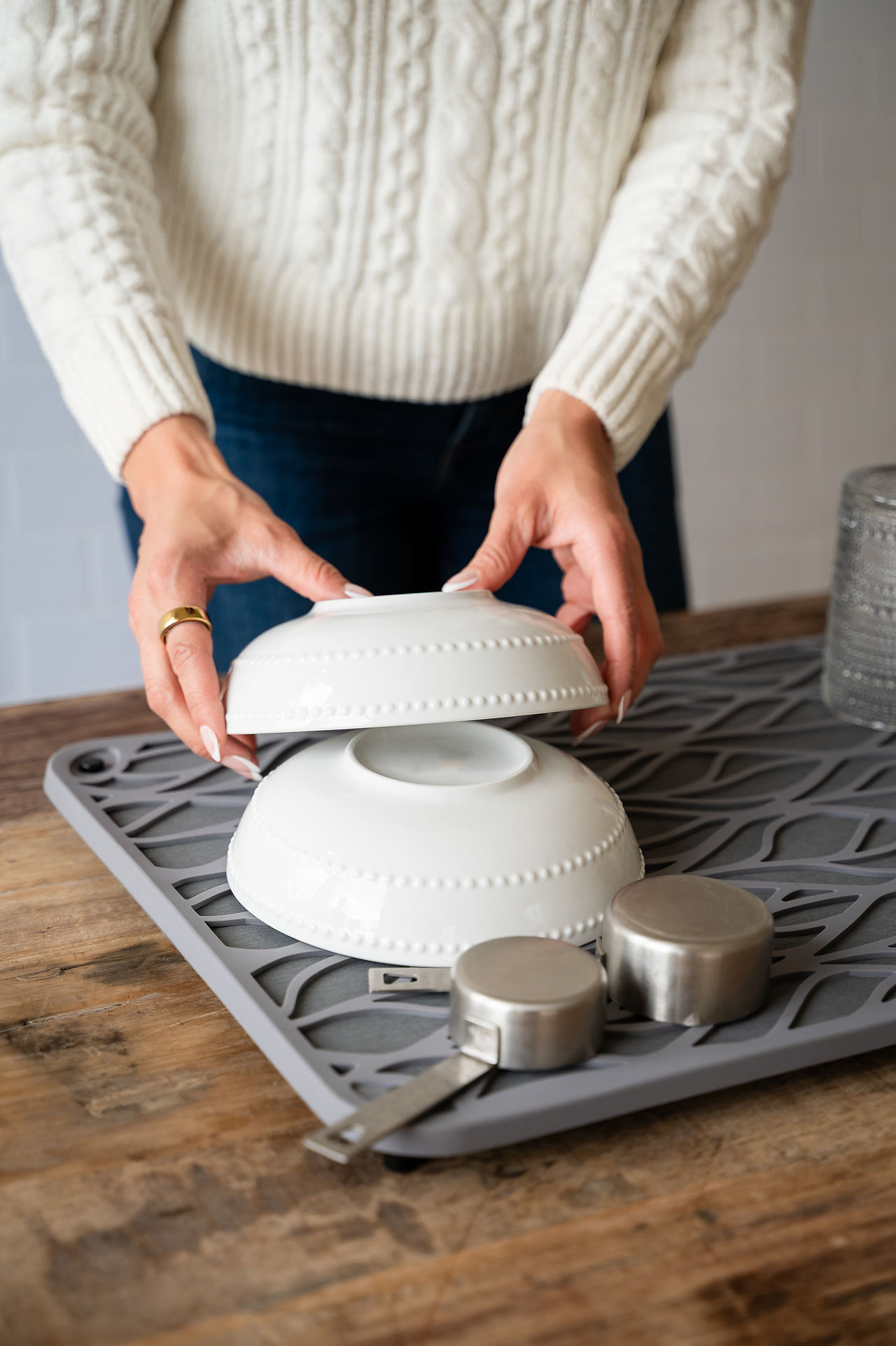 A hand stacking dishes. 