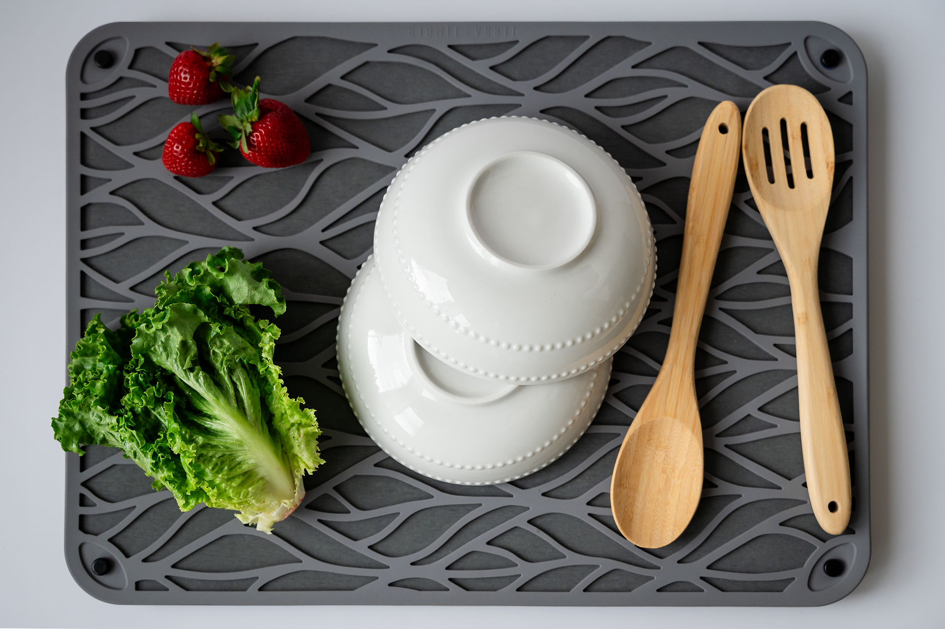 Tableware and veggies on a drying mat. 