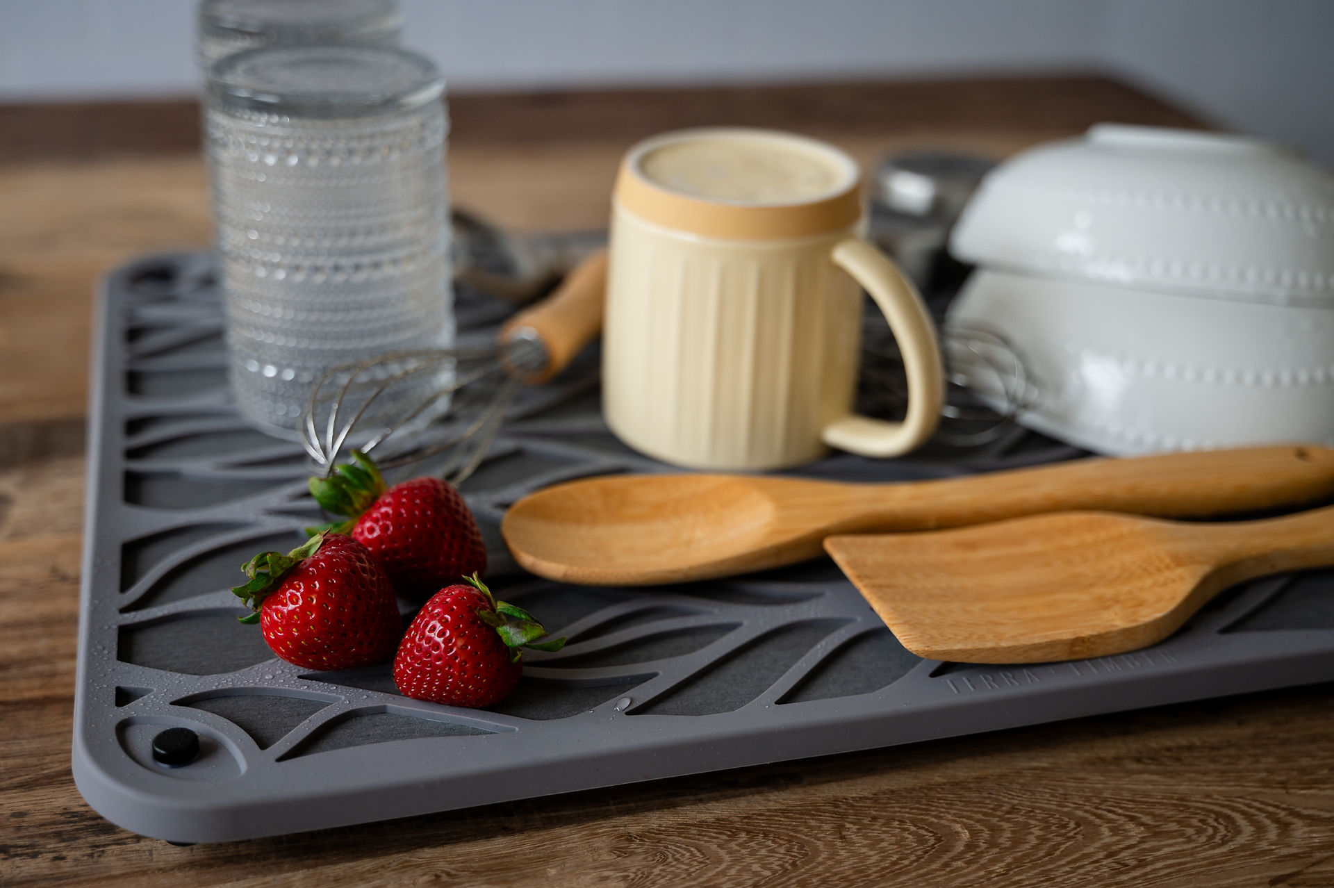 A drying mat with silverware on it. 