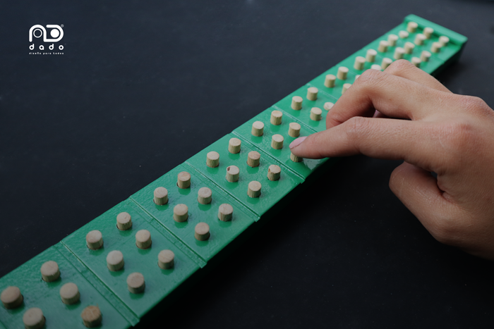 Imagen de una persona usando la regleta pre-braille sencilla