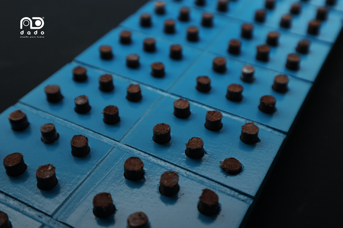 Imagen de regleta pre-braille doble en detalle, es perforada y con pines madera
