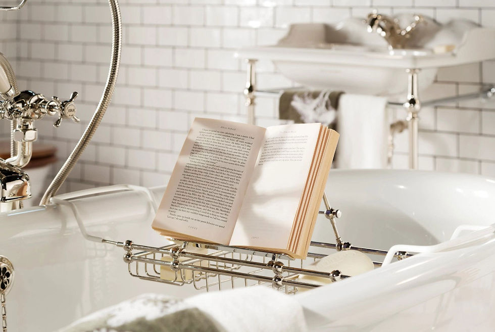 White bathtub with gold details and gold book holder