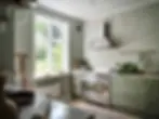 Kitchen with limewashed walls, window facing the garden and appliances