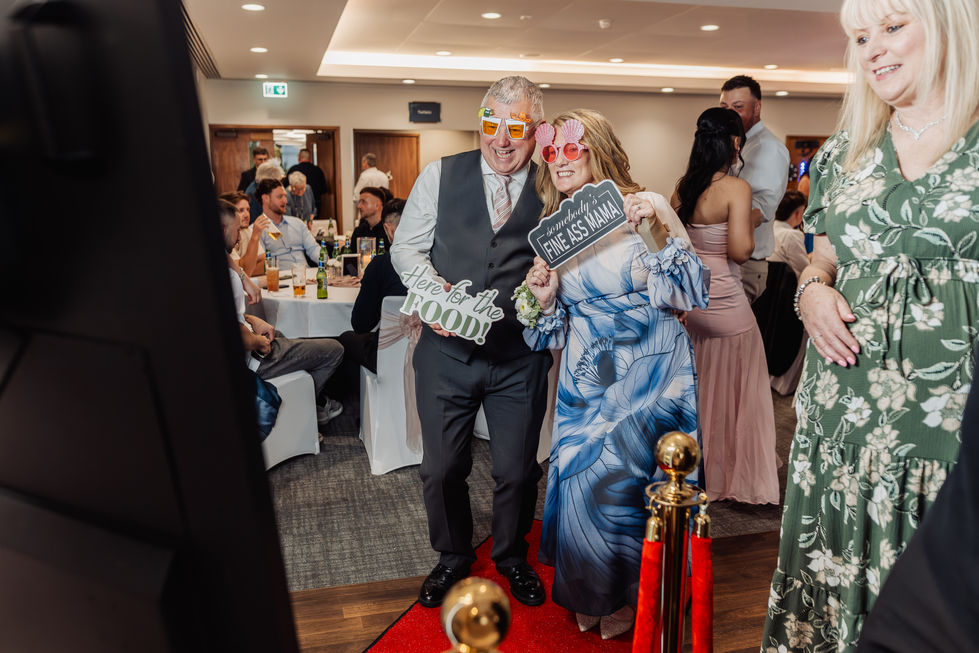 Couple posing with props at an event.